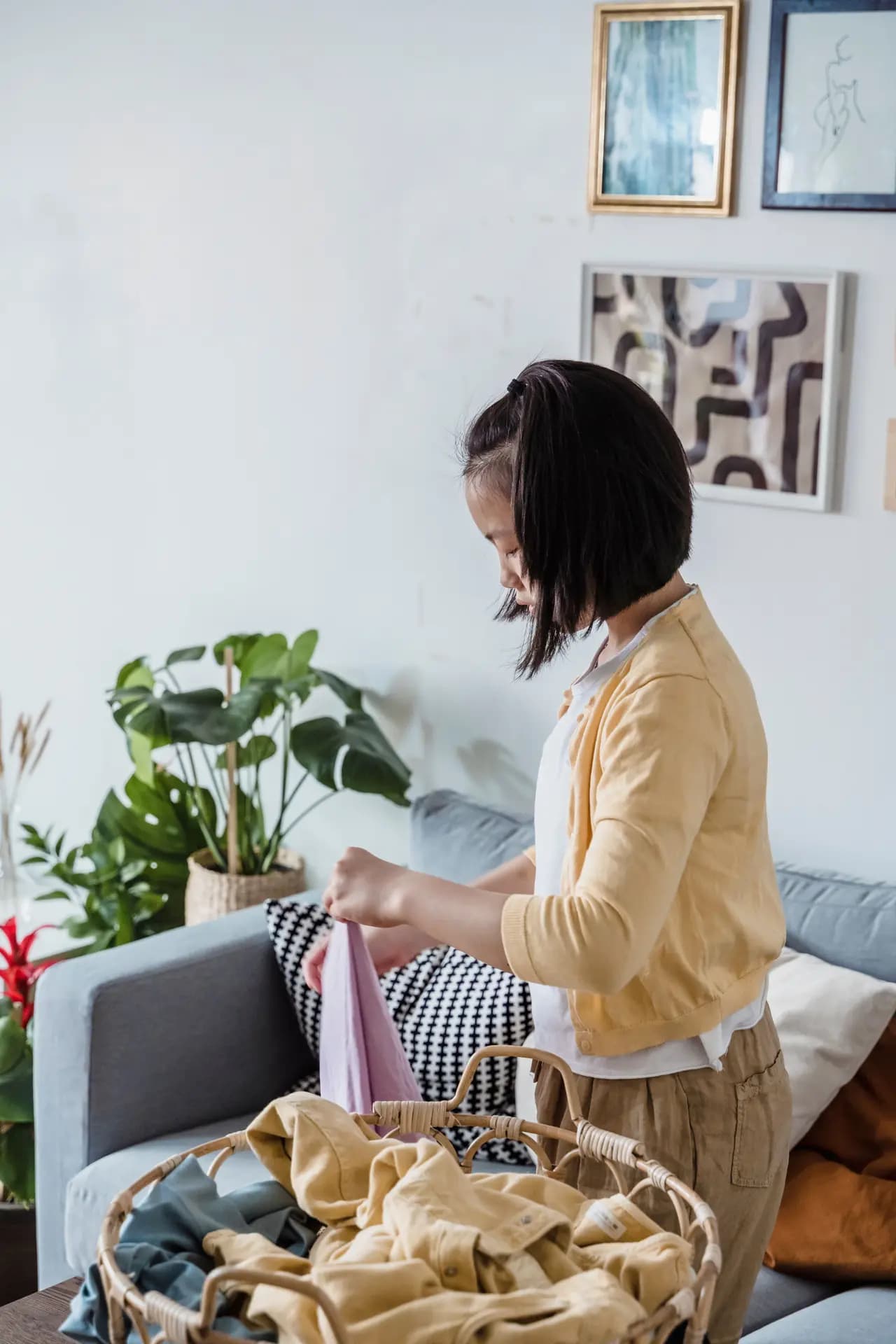 A girl making a bed in a bright room