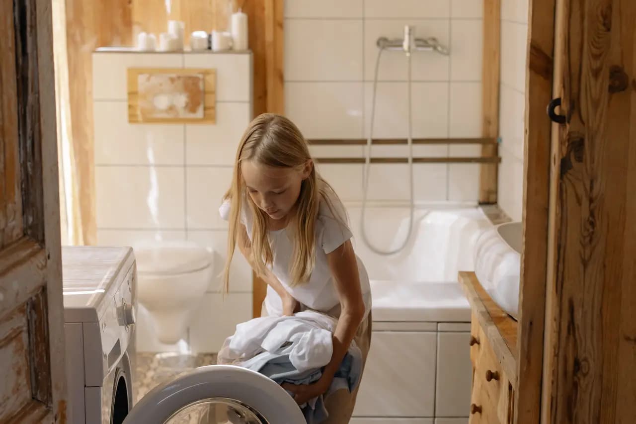 A girl loading a washing machine