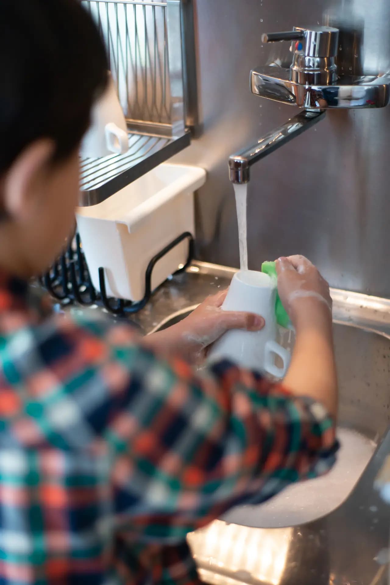 A child washing up at a kitchen sink